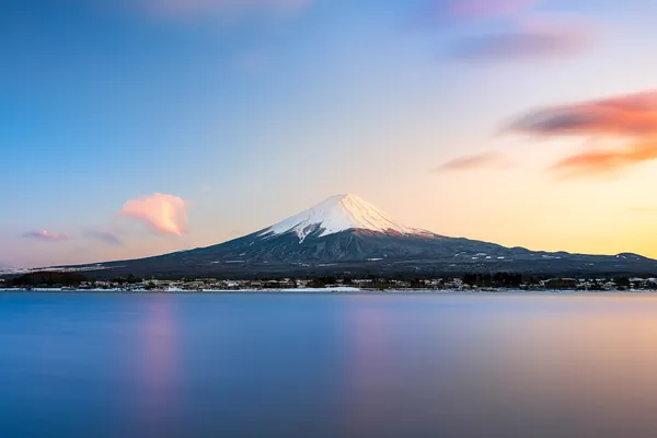 Snow-capped Mount Fuji at sunset above a calm lake, Japan