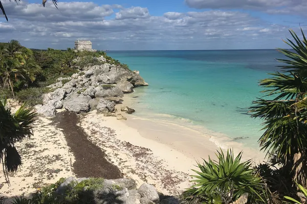 Tulum beach with turquoise sea below the Maya ruins on the cliff, Mexico